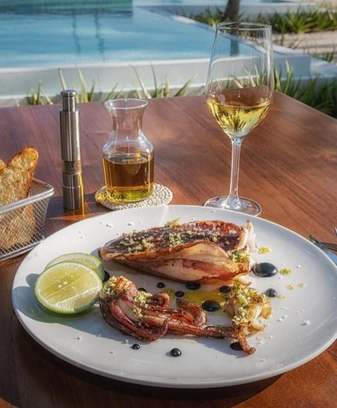 seafood platter and glass of white wine at 81 palms beachfront restaurant